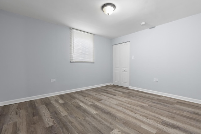 unfurnished room featuring baseboards and wood finished floors