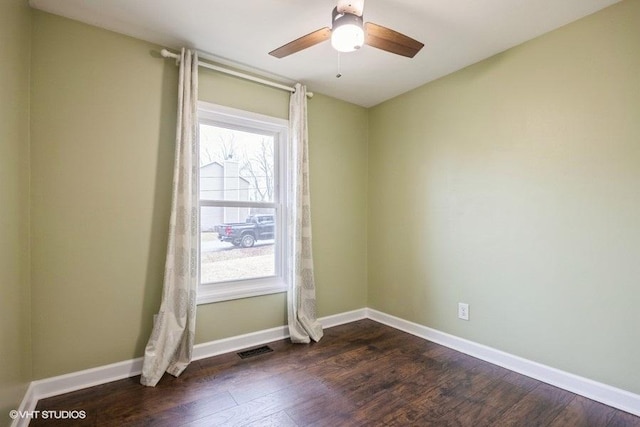 empty room with dark hardwood / wood-style floors and ceiling fan