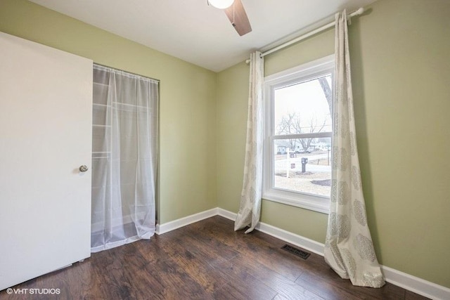 unfurnished room featuring dark wood-type flooring and ceiling fan