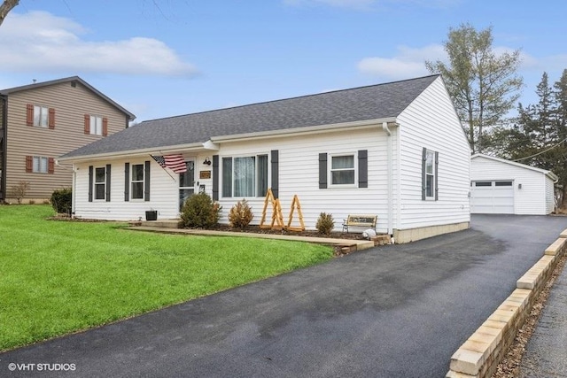 view of front of home featuring a garage, an outdoor structure, and a front lawn