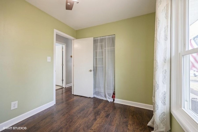 unfurnished room with dark wood-type flooring and a wealth of natural light