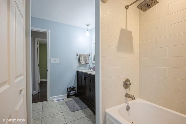 bathroom with tiled shower / bath combo, vanity, and tile patterned flooring