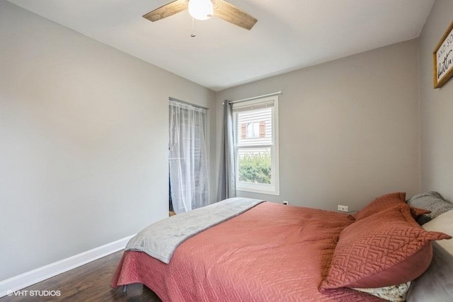 bedroom with dark hardwood / wood-style flooring and ceiling fan