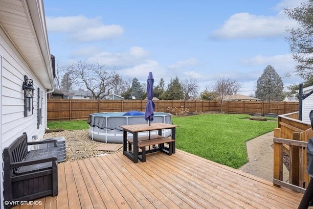 wooden terrace featuring a fenced in pool and a yard