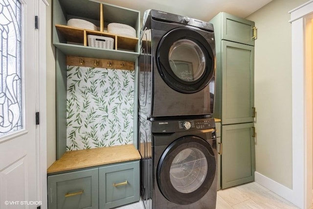 laundry area featuring cabinets and stacked washer and dryer