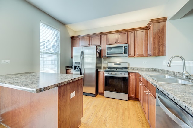 3460 Bradbury Cir, Aurora, IL 60504 - kitchen with appliances with stainless steel finishes, a sink, light wood-style flooring, a peninsula, and brown cabinetry