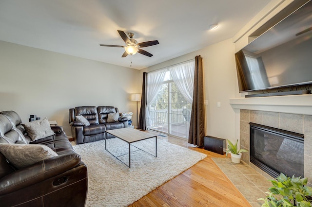 3460 Bradbury Cir, Aurora, IL 60504 - living room featuring ceiling fan, a tiled fireplace, wood finished floors, and baseboards