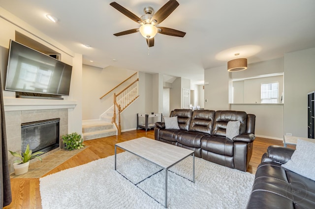 3460 Bradbury Cir, Aurora, IL 60504 - living room featuring stairway, ceiling fan, wood finished floors, and a tiled fireplace