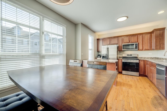3460 Bradbury Cir, Aurora, IL 60504 - kitchen with stainless steel appliances, a sink, light wood-type flooring, and brown cabinetry