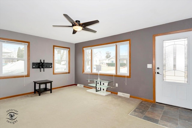 entrance foyer featuring dark carpet and ceiling fan