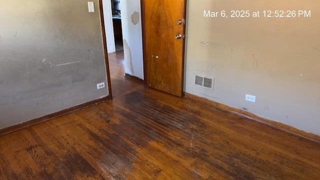 empty room featuring visible vents, baseboards, and hardwood / wood-style floors