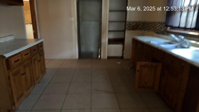 kitchen featuring light tile patterned flooring and brown cabinetry