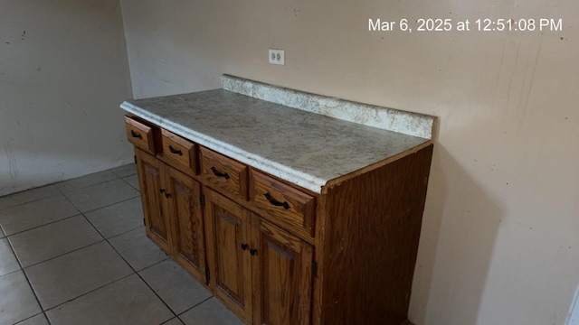 kitchen featuring light tile patterned floors, brown cabinets, and light countertops