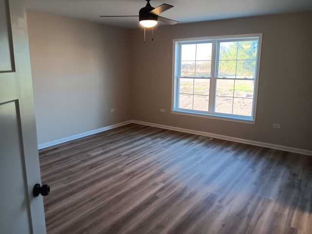 empty room featuring ceiling fan and dark hardwood / wood-style flooring