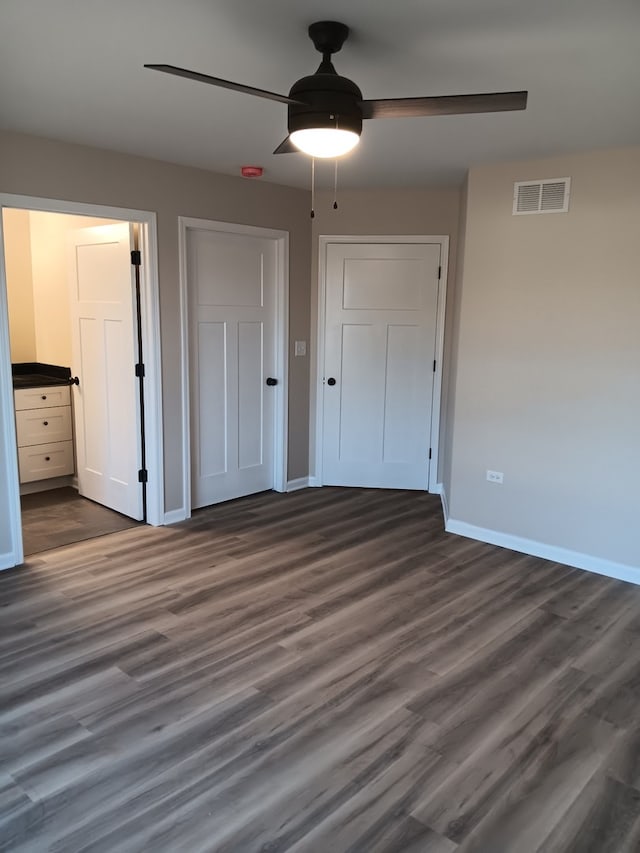 unfurnished bedroom featuring dark hardwood / wood-style floors and ceiling fan