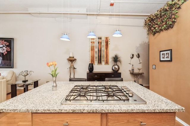 kitchen with stainless steel gas cooktop and decorative light fixtures