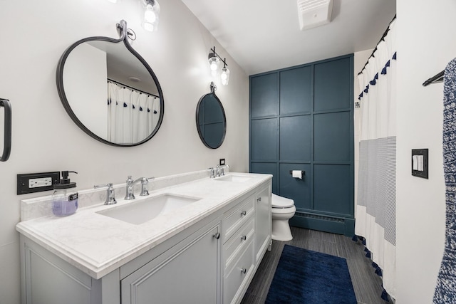 bathroom with vanity, a baseboard radiator, and toilet