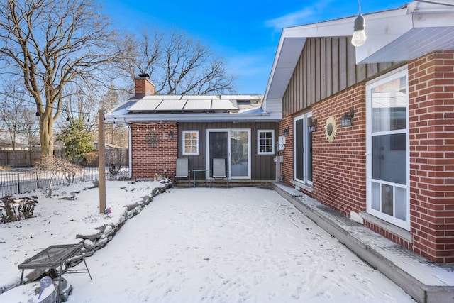 view of snow covered rear of property