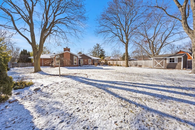 yard covered in snow featuring a storage unit