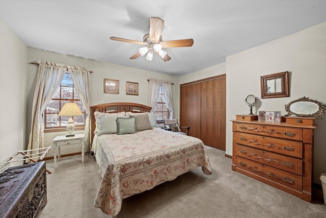 carpeted bedroom with multiple windows, a closet, and ceiling fan