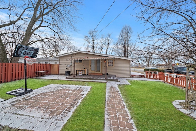 back of property with a yard and a patio area