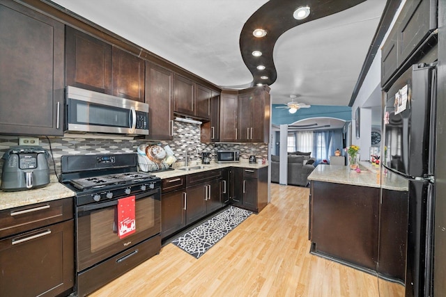 kitchen featuring sink, ceiling fan, dark brown cabinetry, black appliances, and light hardwood / wood-style floors