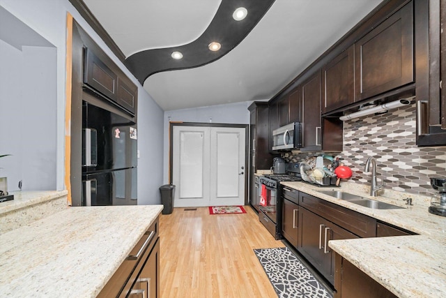 kitchen with sink, light hardwood / wood-style flooring, tasteful backsplash, black appliances, and light stone countertops