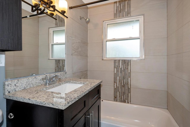 bathroom with tiled shower / bath and vanity