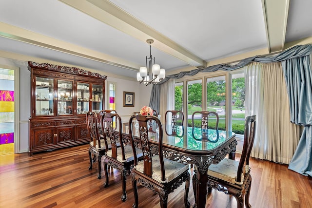 dining room with hardwood / wood-style floors, an inviting chandelier, and beam ceiling