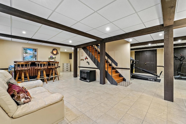 living room featuring bar area and a drop ceiling