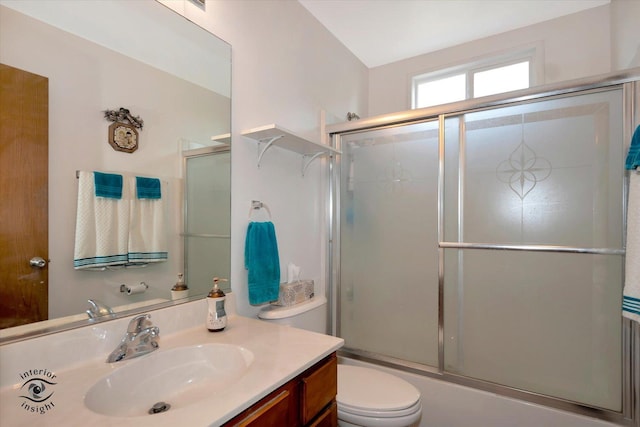 full bathroom featuring vanity, shower / bath combination with glass door, and toilet