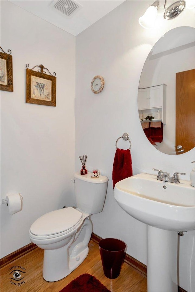 bathroom featuring wood-type flooring and toilet