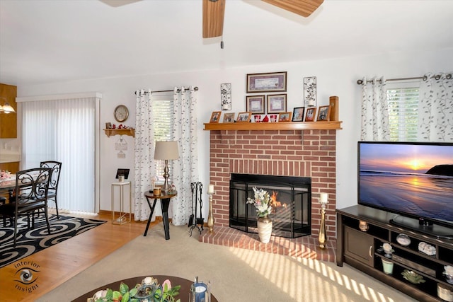 living room with carpet flooring, a fireplace, ceiling fan, and plenty of natural light