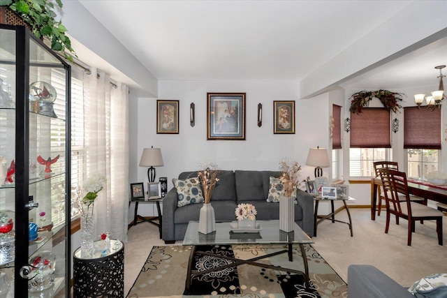 carpeted living room with a chandelier