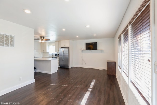 unfurnished living room with dark wood-type flooring, ceiling fan, and sink