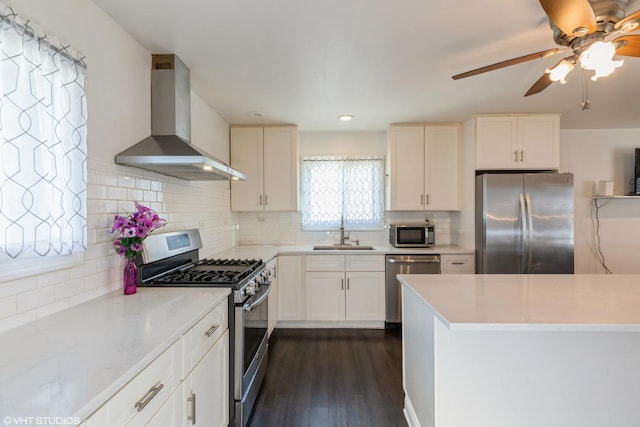 kitchen with dark hardwood / wood-style floors, sink, white cabinets, stainless steel appliances, and wall chimney range hood