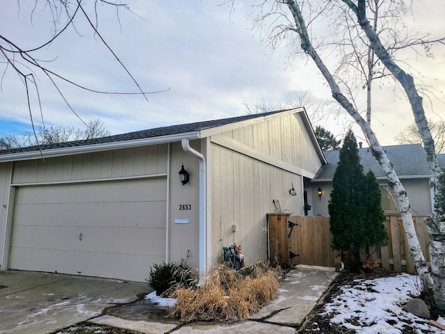 view of property exterior with fence and roof with shingles