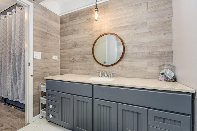 bathroom featuring vanity and tile walls