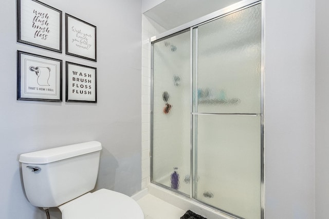 bathroom featuring a shower stall and toilet