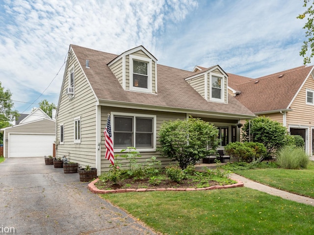 new england style home featuring an outbuilding, cooling unit, a garage, and a front lawn