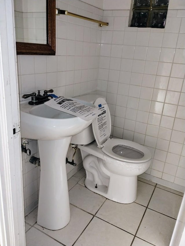 bathroom with tile patterned floors, toilet, and tile walls