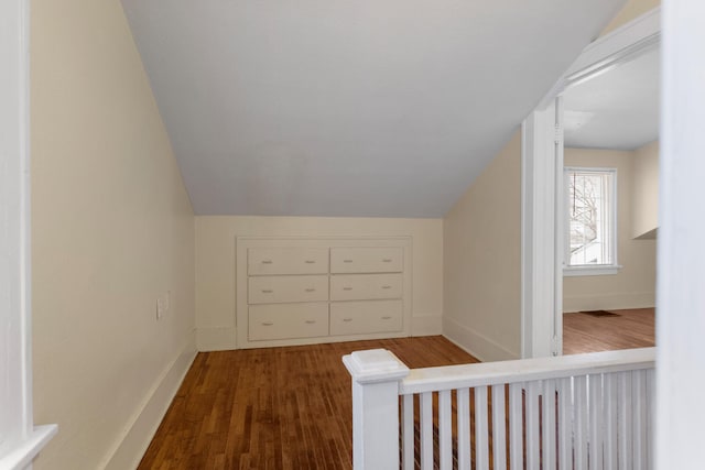 bonus room with vaulted ceiling and dark hardwood / wood-style flooring