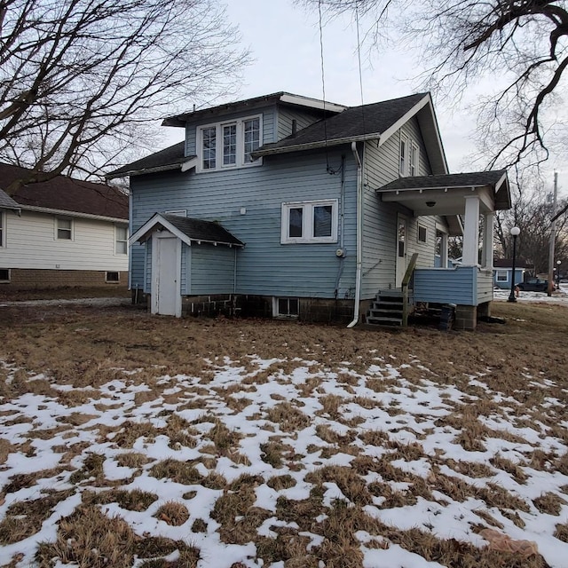 view of snow covered rear of property