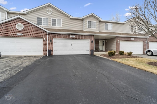 view of property with driveway and brick siding