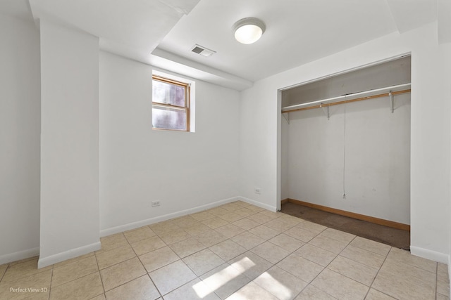 unfurnished bedroom featuring a closet, visible vents, baseboards, and light tile patterned flooring