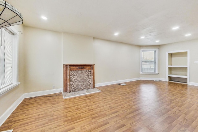 unfurnished living room featuring recessed lighting, light wood-style flooring, and baseboards