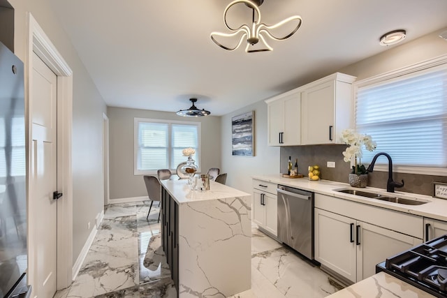 kitchen featuring dishwasher, sink, white cabinets, a kitchen breakfast bar, and a center island