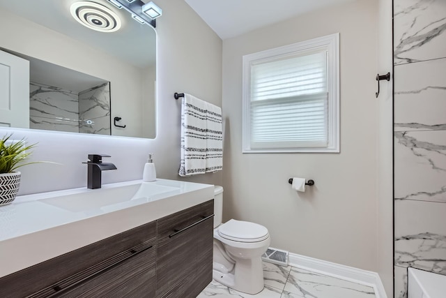 bathroom with vanity, a tile shower, and toilet