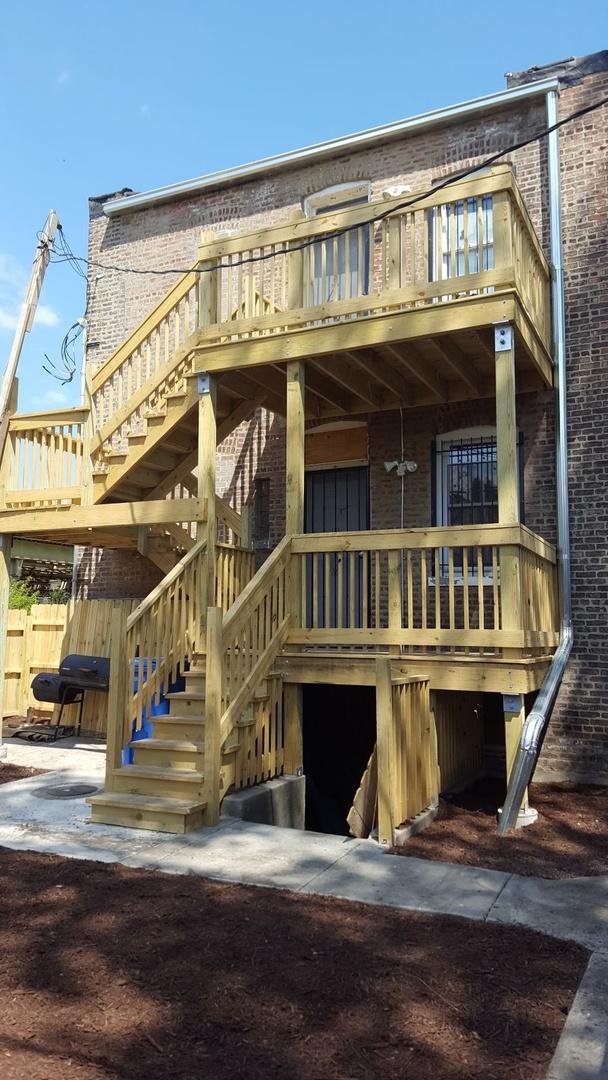 rear view of property with stairs and brick siding