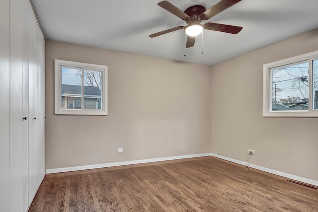 spare room with dark hardwood / wood-style flooring and ceiling fan